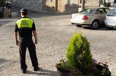 Un vigilante municipal controla el orden público en la plaza de un pueblo de la provincia de Jaén. /